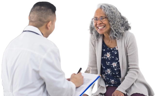 A women happy and listening to her doctor who is reviewing his clipboard.