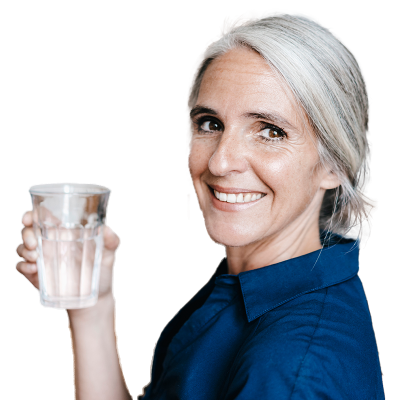A women smiling and holding up a glass of water